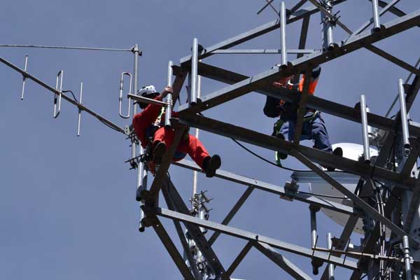 Telstra volunteers installing antenna